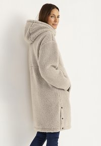 Fleece-gevoerde jas in lichtgrijs met een capuchon, lange mouwen, zijzakken en drukknoopsluitingen langs de onderrand. Zachte, gestructureerde stof.