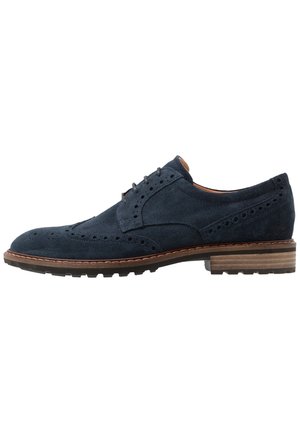 Marineblaue Herren-Brogue aus Wildleder mit Flügelkappen-Design, perforierten Details, braunem gestapeltem Absatz und schwarzer Gummisohle.