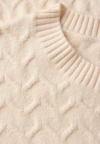 Sweter w kolorze kremowym, z dzianiny, posiadający teksturowany wzór w zygzak, z prążkowanym kołnierzem i miękkim, puszystym materiałem.