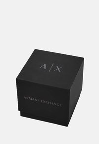 Musta ruutukujuline kast matte viimistlusega, mille peal on reljeefne hõbedane "A/X" logo ja küljel "ARMANI EXCHANGE" tekst.