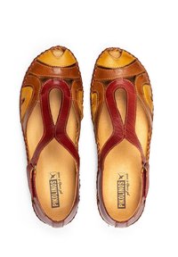 Twee open teen sandalen gemaakt van bruin en bordeauxleer. Kenmerken zijn uitgesneden ontwerpen, stiksels en een gevoerde binnenzool.