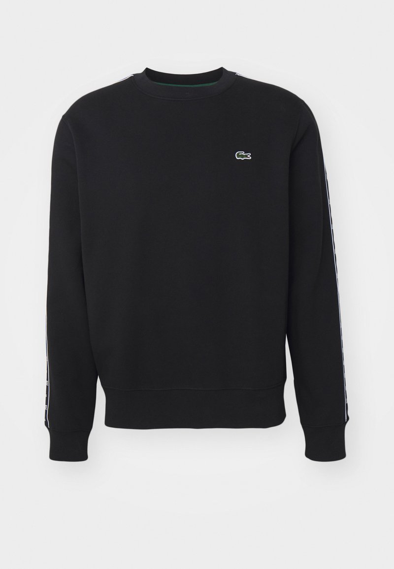 Schwarzer Sweatshirt mit Rundhalsausschnitt, aus Baumwollmaterial gefertigt. Mit kleinem grünen Lacoste-Logo und kontrastierenden Seitenstreifen.