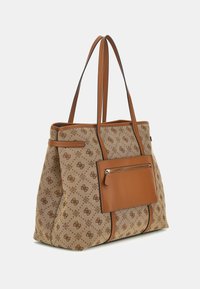Sac fourre-tout en toile beige avec des accents en cuir marron, présentant un extérieur à motif et une poche zippée à l'avant. Deux longues anses pour un transport facile.