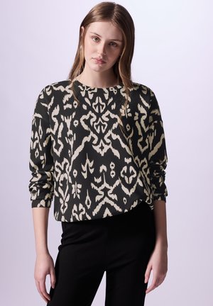 Pullover a maniche lunghe nero e crema con motivo, caratterizzato da un collo rotondo e una vestibilità comoda. Abbinato a pantaloni neri.
