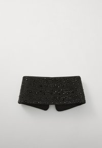 Mustmustriip, mida kaunistavad arvukad väikesed, säravad mustad detailid, sile tekstuur, lai kuju ja ümarad servad, et saavutada vormiv välimus.