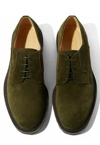 Scarpe in camoscio verde oliva con lacci, punta arrotondata, suola in contrasto marrone scuro e lacci verdi abbinati. Fodera interna liscia.