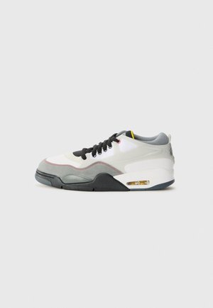Sneaker bianca e grigia bassa con lacci neri, suola con cuscinetto ad aria e dettaglio giallo nella fodera interna, mostrata di profilo su sfondo bianco.