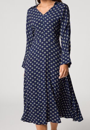 Granatowa sukienka z długim rękawem, z białym i różowym kwiatowym wzorem, dekoltem w serek, dopasowaną talią i zwiewną spódnicą sięgającą do połowy łydki.