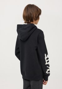 Felpa nera con tasca a marsupio, cappuccio regolabile con cordino e stampa grafica bianca sulla manica sinistra. Tessuto morbido, vestibilità comoda.