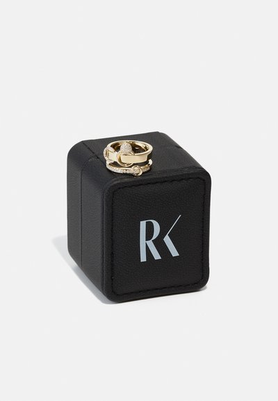 Gold ring set features a textured design and small clear stones, presented on a black square box with a silver logo.