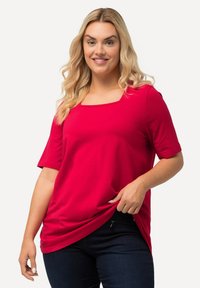 T-shirt rossa a maniche corte con scollo quadrato, realizzata in tessuto morbido, caratterizzata da una vestibilità comoda e da una leggera caduta all'orlo.