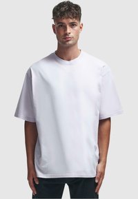 Løs pasform, kortærmet t-shirt i lys lavendel bomuld, med rund halsudskæring og lige søm. Glat tekstur, minimalistisk design.