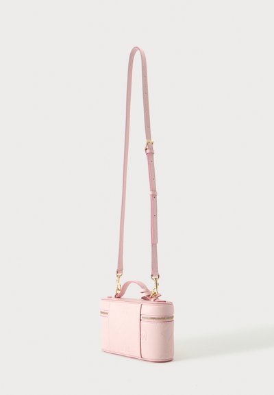 Μικρή ορθογώνια ροζ τσάντα crossbody με ρυθμιζόμενο ιμάντα, χρυσά φερμουάρ και πάνω λαβή σε λευκό φόντο.