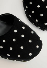 Juodi aksominiai basutės, papuoštos vienodai išdėstytais apvaliais skaidriais cirkoniais ant paviršiaus ir šonų.