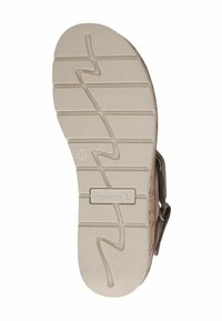 Beige kummist jalanõu tald, millel on tekstureeritud sooned ja väike logo. Omab eristuvat sakilise mustriga kuju, mis tagab parema haakumise ja tõukumise.