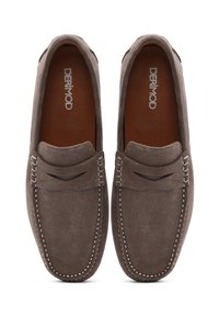 Mocasines de ante marrón con costuras blancas, que presentan un diseño cosido en la parte frontal y una superficie suave y texturizada. Logo de la marca visible en el interior.