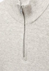 Svetle šedý žebrovaný svetr s vysokým límcem, obsahující zip do poloviny, vyrobený z měkké látky, s jemnou strukturou po celém povrchu.