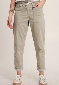 Helle graue, leichte, lässige Hose mit einem elastischen Bund, Kordelzug und umgeschlagenen Säumen; verfügt über Fronttaschen und eine glatte Textur.