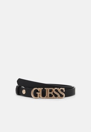 Czarny skórzany pasek z teksturowanym wykończeniem i złotą metalową klamrą z napisem "GUESS" wielkimi literami.
