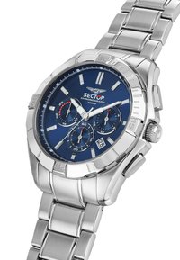 Sølv rustfrit stål chronograph ur med en blå urskive, der har tre undermålere, lysende visere og en datovisning ved 6-tiden.