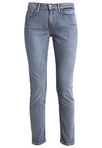 Jeans de denim azul claro con un corte ajustado, diseño de cinco bolsillos, cremallera y cierre de botón. Detalles de desvanecimiento sutil y costuras.