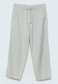 Pantalon gris clair à taille élastique avec cordon, coupe ample, deux poches plaquées devant, et ourlets avec revers.