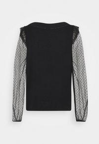 Musta paita, jossa on läpinäkyvät, pistekuosiset hihat. Varustettu pyöreällä kaula-aukolla ja kiinteällä vartalolla, mikä luo tekstuurista visuaalista kontrastia.