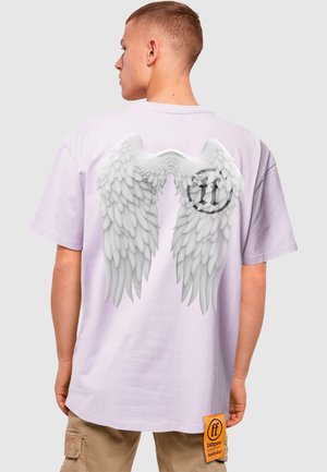Fliederfarbendes Oversized-T-Shirt mit einem Grafikdesign von weißen Engelsflügeln auf der Rückseite, darunter ein kreisförmiges Logo. Enthält ein Markenetikett.