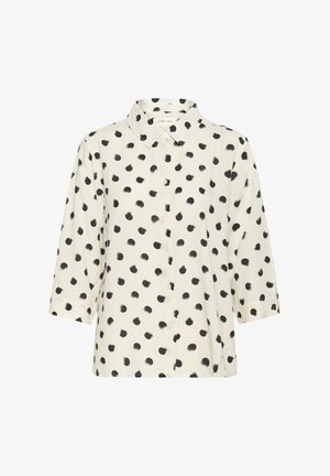 Krēmveida blūze ar melniem punktu rakstiem, ar pogu aizdari priekšpusē un apkakli. Iespējas ar trīs ceturtdaļu piedurkņu un brīvu piegriezumu. Mīksta auduma tekstūra.