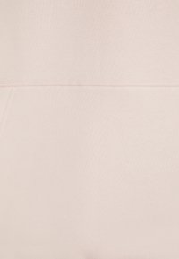 Tessuto di felpa rosa chiaro con superficie morbida e texture visibile, cuciture evidenti. Presenta un design semplice senza motivi o decorazioni.