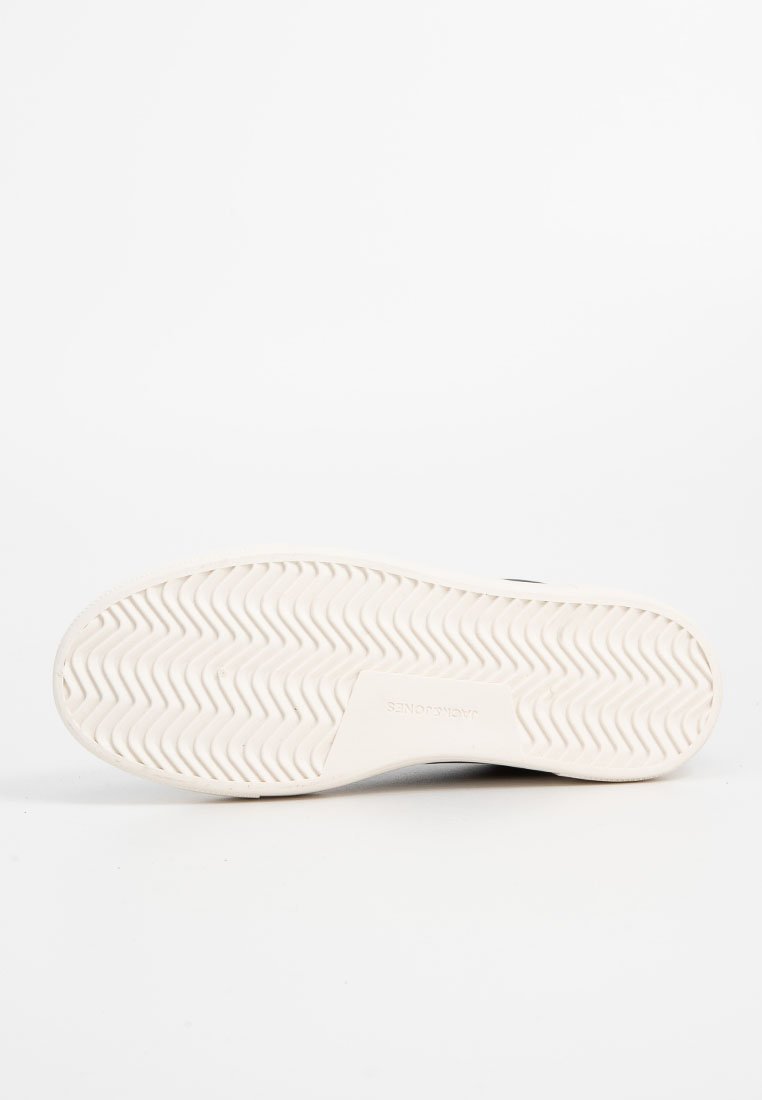 Suela de zapatilla blanca con una textura ondulada y logo. Forma plana y redondeada con soporte en los laterales y el talón para mayor estabilidad. Diseño limpio, con un detalle mínimo.