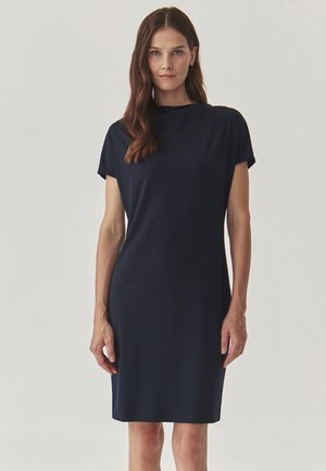 Dunkelblaues Kleid mit kurzen Ärmeln, gerader Silhouette, hohem Kragen und glattem Stoff. Knielanger Saum ohne sichtbare Muster oder Akzente.