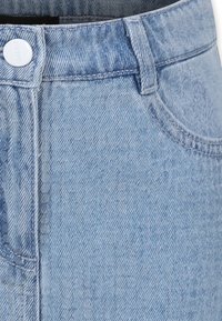 Falda de mezclilla azul clara con cintura alta, presillas para cinturón, cierre frontal de botones y bolsillos laterales con una textura suave.