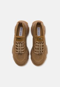 Braune gestrickte Sneakers mit strukturierter Oberfläche, abgerundetem Zehenbereich und dekorativen elastischen Schnürsenkeln. Transparente Gummisohle mit Logodetail.