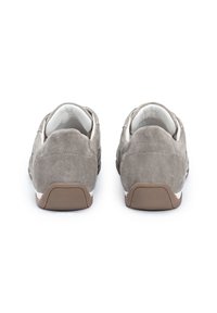 Šedé semišové tenisky s nízkým profilem, s bílým lemováním a hnědou gumovou podrážkou. Obsahují jemnou texturu a jednoduché designové prvky.