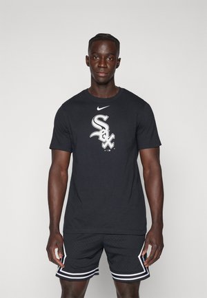 Camiseta de algodón negra con un logo blanco de "Sox", combinada con pantalones cortos negros que tienen franjas laterales blancas y una textura de malla. Diseño simple y deportivo.