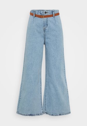 Light blue wide-leg jeans with a high waist, elastic band, and a contrasting brown belt. Features visible stitching and a frayed hem.