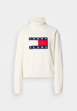 Pulover crem cu guler înalt, cu textură reiată, având un logo "TOMMY JEANS" bleumarin și roșu și un design pătrat pe partea din față.