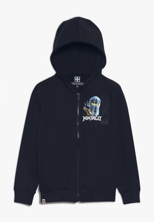 Mørkeblå hættejakke med lynlås og Ninjago-figur grafik samt teksten "NINJAGO" på brystet, med hætte og lange ærmer.