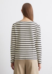 Gestreiftes Langarmoberteil in Creme und Schwarz, mit Rundhalsausschnitt und lässiger Passform. Der Stoff hat eine weiche Textur und verfügt über horizontale Streifen.