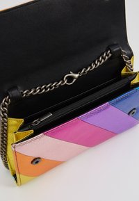 Mult Kleuren leren clutch met een kettingriem. Heeft diagonale secties in roze, paars, blauw, oranje en geel. Zwarte voering en zip pocket.