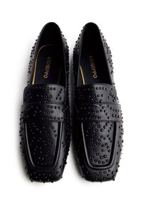 Mocassins en cuir noir avec des accents cloutés, dotés d'une semelle plate, d'un bout carré et d'une marquage doré contrasté sur la semelle intérieure.
