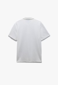 Polo shirt bianco a maniche corte, con texture a coste e colletto classico. Nessun logo o motivo visibile. Design semplice e pulito.