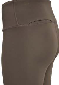 Bruna högmidjade leggings i stretchigt material, med platta sömmar och ett brett midjeband för komfort. Slät textur, kroppsnära design.