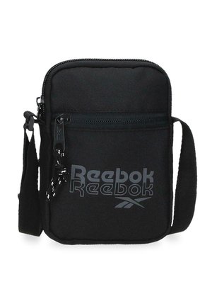 Bolso bandolera compacto negro de Reebok con bolsillo frontal con cremallera, correa ajustable y logo impreso en el panel frontal.