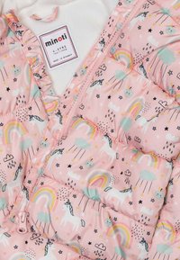 Vaaleanpunainen pehmeä takki, jossa on yksisarvisten, sateenkaarten ja pilvien kuvio. Varustettu vetoketjulla ja pehmeällä sisävuorella. Röyhelöreuna kaula-aukon ympärillä.