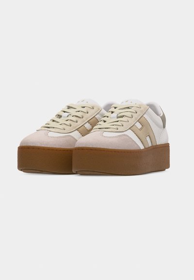 Paire de baskets plateformes beige et blanches avec semelles épaisses en caoutchouc marron, bouts en daim beige et bandes latérales beiges avec lacets.