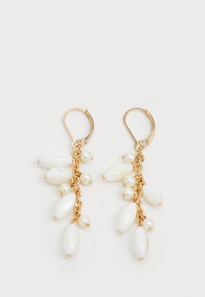 Kultaiset roikkuvat korvakorut, joissa on useita valkoisia soikeita helmiä ja pieniä helmiä, on järjestetty putoavan muotoiseen suunnitteluun ketjussa.