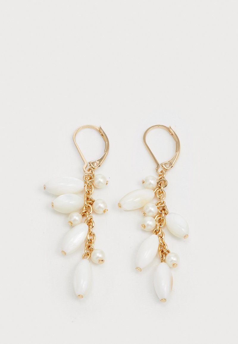 Des boucles d'oreilles pendantes en ton or présentent plusieurs perles ovales blanches et petites perles, disposées dans un design en cascade sur une chaîne articulée.