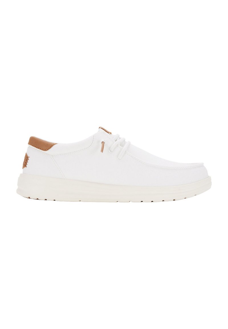Scarpe da ginnastica bianche in tela con suola color crema chiaro, caratterizzate da un dettagli in pelle marrone sul tallone e un semplice design con lacci.